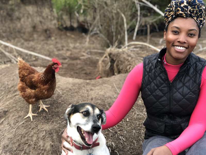 team member smiling with dog and chicken
